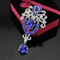 Dettaglio macro della spilla a corona con cristalli blu a goccia e strass brillanti - Base d'Argento / Blu Reale