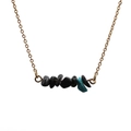 Collier chaîne dorée avec pierres noires et pendentif turquoise sur fond blanc - Pierre concassée noire et turquoise (3)