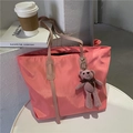 Pink nylon tote bag with cute bear charm on a cafe table, stylish large shoulder bag - With Teddy Bear / Pink