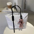 White large capacity tote bag with black straps and a pink bear charm on a table - With Teddy Bear / White