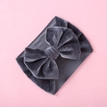 Detailed view of grey velvet baby headband with large bow on pink background - Dark Gray