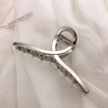 Detail einer minimalistischen silbernen Haarklammer aus Metall mit gedrehtem Legierungsdesign - Silber-Kreuz