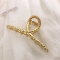 Detailed view of large golden metal hair claw clip with unique hammered metal texture - Matte Gold-Hammered Cross