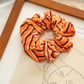 Macro detail of striped orange velvet hair scrunchie with soft satin sheen texture - Orange Black Stripes