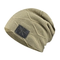 Detail view of olive green cable knit beanie featuring a square leather logo patch - Khaki