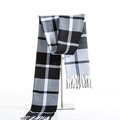 Detail of classic black and white plaid scarf with fringe on a metal stand display - White Striped Grid