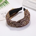 Detailed view of bronze knotted headband featuring intricate golden embroidery patterns - Coffee
