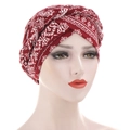 Détail du turban à motif paisley rouge avec nœud tressé sur un mannequin de vitrine - Paisley Ethnique / Bordeaux