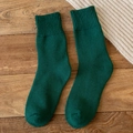 Deep green wool blend thermal socks for women with cozy ribbed cuffs on wood floor - One Size / Green