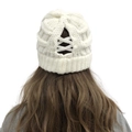 Detail of white chunky knit beanie with ponytail opening and cross strap design - White