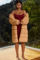 Detail of a camel faux fur long coat paired with a burgundy silk dress in a luxury setting - Camel
