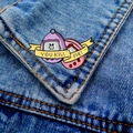 Detail of retro Tamagotchi style enamel pins on denim jacket with You Kill Me text - Virtual Pet