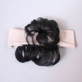 Detalle de un moño de pelo rizado sintético en una diadema de punto suave para bebés - Moño Único / Caqui Beige