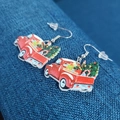 Macro shot of red Christmas truck acrylic earrings with tree detail on blue background - Christmas Truck