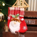 Close-up of red felt Christmas stocking with Santa Claus applique and plaid cuff detail - Plaid Santa
