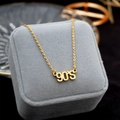 Collana a doppio strato placcata oro con ciondolo 90'S su una scatola per gioielli - Collana anni '90