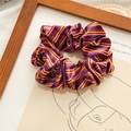 Purple and orange striped velvet scrunchie hair accessory on minimalist background - Purple Orange Stripes