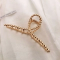 Detailed close-up of large golden metal claw clip with elegant twisted texture design - KC Gold-Twisted Cross