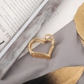 Detail of a large golden hollow heart-shaped alloy claw clip on a gray fabric background - Small Gold Heart