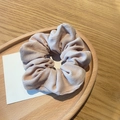 Detail of soft pink corduroy scrunchie on wooden tray with textured fabric detail - Khaki