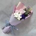 Detail of pink and purple soap rose bouquet with striped ribbon on gray background - Purple