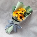 Macro shot of artificial sunflower bouquet with green paper wrap and striped ribbon - Sunflower