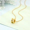 Elegante goldene Zylinder-Halskette aus Titan mit funkelnden Kristallen auf grünem Papier - Kabel Kette / Gold