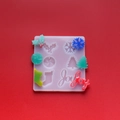 Macro shot of 3D Christmas silicone mold set with snowflake, tree and joy resin charms - Christmas Letter Sock Mold