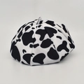 Close-up of wool beret with black and white cow print texture and classic top stem - M (56-58cm) / White