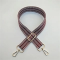 Close-up of red and white geometric woven strap with gold metal lobster clasps - Brown