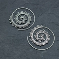 Vintage silver lotus spiral hoop earrings with bohemian tribal textures on stone background - Antique Silver