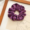 Close-up of velvet Halloween hair scrunchie with orange pumpkin print on purple fabric - Purple Pumpkin Print