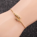 Close-up of golden snake bracelet with green zircon eyes on a hand model - Box Chain Snake 4
