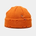 Detail van de oranje gebreide muts met distressed gaten en zilveren metalen ringen accenten - M (56-58cm) / Oranje