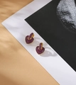 Luxuriöse Herzohrringe aus Gold mit magentafarbenen Zirkonia auf schlichtem Hintergrund - Rubinrot