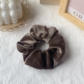 Deep brown velvet hair scrunchie shown on a white textured background with home decor - Dark Brown