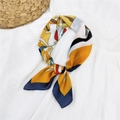 Artistic silk square scarf featuring yellow and navy blue abstract print tied in a knot - Model Orange