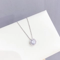 Elegant silver halo necklace with a round sparkling cubic zirconia on a white surface - Round Halo Design / Silver