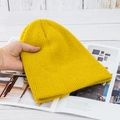 Detailaufnahme der Textur und Elastizität der gelben Strickmütze auf einem Magazin - Hohe Elastizität / Ingwergelb