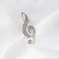 Close-up of silver treble clef brooch with shimmering rhinestones on white silk fabric - Silver Full Rhinestone Treble Clef