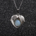 Stainless steel necklace featuring angel wing pendant and white bead on black background - Aquamarine