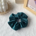 Elegant emerald green velvet scrunchie hair accessory with soft texture on white fabric - Dark Green