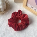 Vibrant red velvet scrunchie ponytail holder with soft fabric folds and rich luster texture - Red