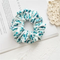 Chouchou en velours aux motifs abstraits rose et bleu sarcelle sur fond blanc - Motif de banderole blanche