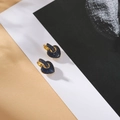 Detailansicht der goldenen Herzohrringe mit dunkelblauen Zirkonia und Klickverschluss - Blau