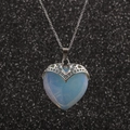 Collier avec pendentif cœur opale bleu clair et chaîne en argent sur fond noir scintillant - Aigue-marine