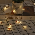 Dettaglio di luci natalizie LED bianco caldo con decorazioni a forma di Babbo Natale - 1m 10-LED (Modello 2AA) / Testa di Babbo Natale con Cappello Rosso