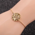 Detail of adjustable gold snake bracelet with star pattern on model wrist with dark background - Box Chain Snake 6