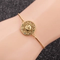 Bracciale dorato con ciondolo stella e luna e pietre colorate su sfondo nero scintillante - Stile catena di metallo / scatola catena