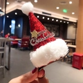 Close-up of a sequined Christmas hat hair clip with Merry Christmas badge and golden star - Letter Style